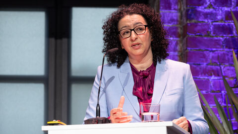 Eine Frau steht an einem Podium und hält eine Rede