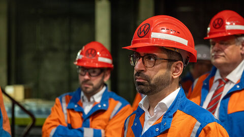 Mehrere Personen tragen Helme und orangene Jacken