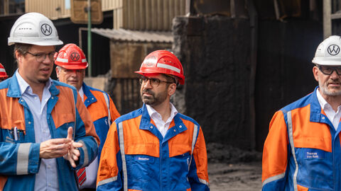 Mehrere Personen tragen Helme und orangene Jacken