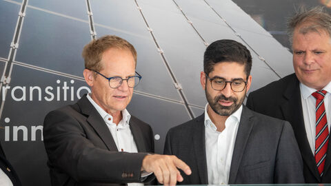 Drei Männer schauen in eine Richtung