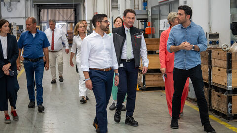 Mehrere Personen laufen durch eine Werkshalle