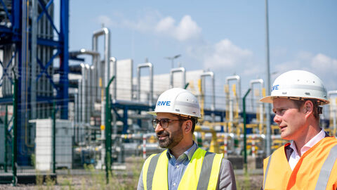 Zwei Männer stehen vor einer Industrieanlage