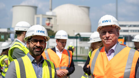 Zwei Männer mit Warnwesten schauen lächelnd in die Kamera