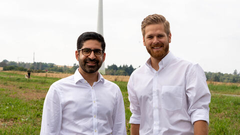 Zwei Männer in weißen Hemden lachen in die Kamera