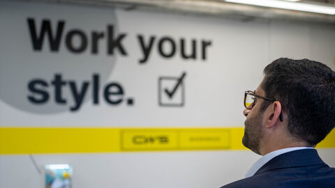 Ein Mann schaut auf ein Schild auf dem steht "Work your style"