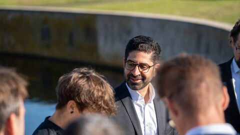 Ein lachender Mann vor einem Becken einer Kläranlage