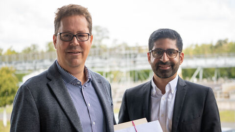 Zwei Männer lachen in die Kamera