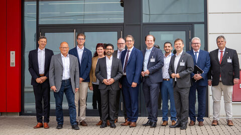 Mehrere Personen stehen vor einem Gebäude