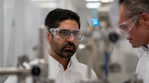 Ein Mann mit Laborbrille und weißem Kittel