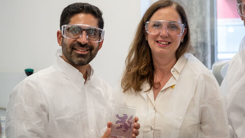 Ein Mann und eine Frau mit Laborbrille und weißem Kittel