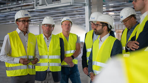 Mehrere Männer mit gelber Warnweste und Helm