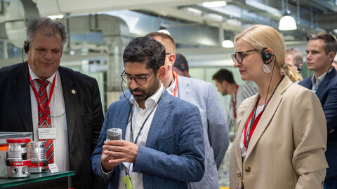 Drei Personen betrachten ein Gerär