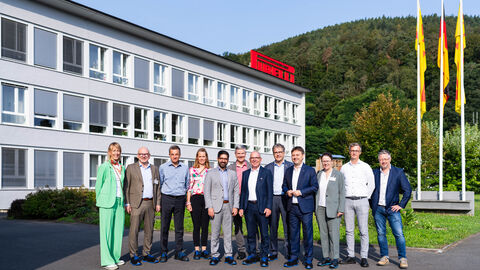 Mehrere Personen stehen vor einem Gebäude