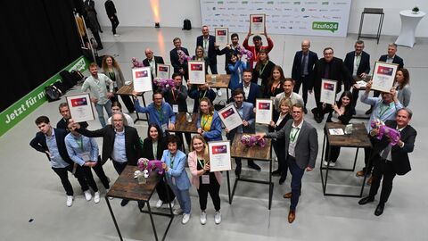 Mehrere Personen halten Urkunden hoch