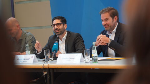 Zwei Männer sitzen auf einem Podium