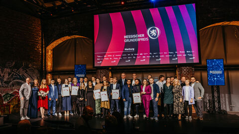 Eine große Gruppe von Personen stehen auf einer Bühne