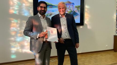 Zwei Männer halten einen Umschlag