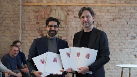 Zwei Personen halten mehrere Mappen