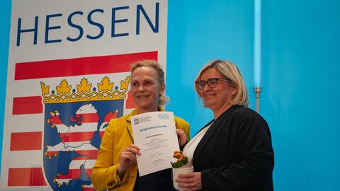 Staatssekretärin Ines Fröhlich beim Nahmobilitätskongress Zwei Frauen stehen auf einer Bühne und halten eine Urkunde