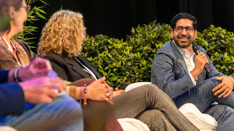 Ein Mann sitzt in einer Talkrunde und spricht in ein Mikro