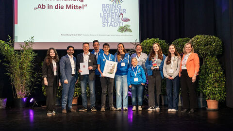 Mehrere Personen stehen auf einer Bühne