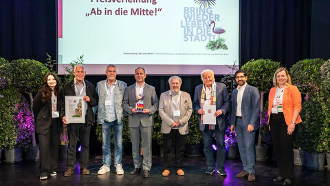 Mehrere Personen stehen auf einer Bühne