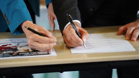 Eine Hand, die einen Vertrag unterschreibt