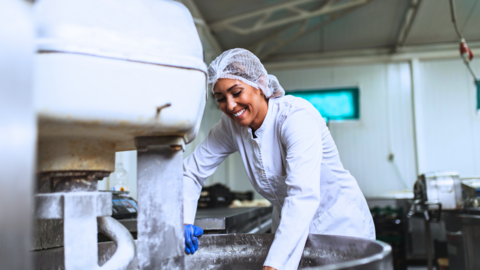 Eine Frau steht in einer Backstubbe einer Bäckerei