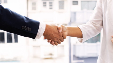 Zwei Hände, die sich einen Handschlag geben
