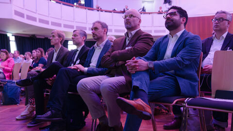 Mehrere Personen sitzen auf Stühlen 