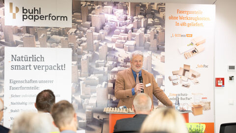 Ein Mann steht auf einer Bühne und hält einen Vortrag