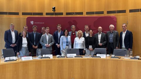 Mehrere Personen stehen vor einer roten Wand