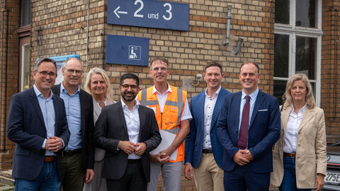 Besuch der Baustelle am Bahnhof Gelnhausen Mehrere Personen stehen vor einem Bahnhofsgebäude