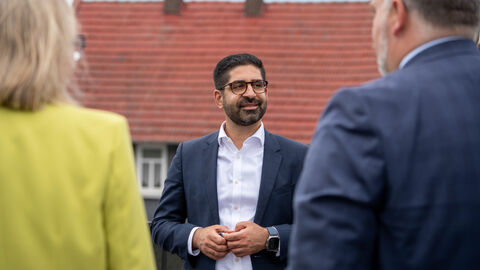 Ein Mann im Anzug lacht in die Kamera