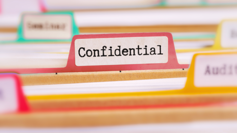Ansicht auf Akten. Auf einer Akte steht confidential, also vertraulich