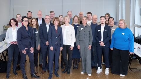 Mehrere Personen stehen in einer Gruppe zusammen