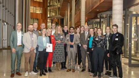 Mehrere Personen stehen in einer Gruppe zusammen 