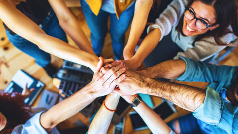Mehrere Hände greifen in der Mitte zusammen