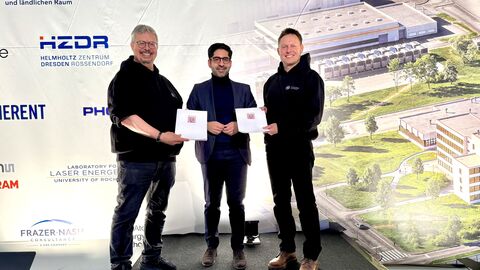 Drei Personen stehen vor einer Wand