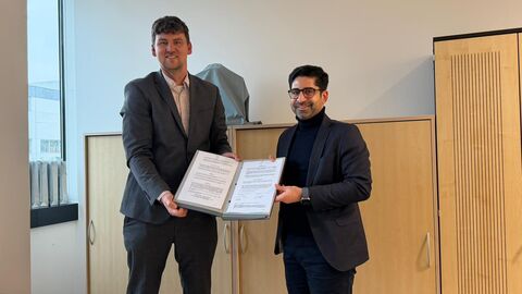 Zwei Personen halten einen Vertrag