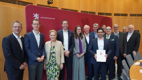 Mehrere Personen stehen vor einer roten Wand