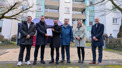 Mehrere Personen stehen vor einem Hochhaus