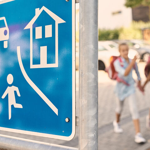 Zwei Kinder gehen in einer Spielstraße zur Schule